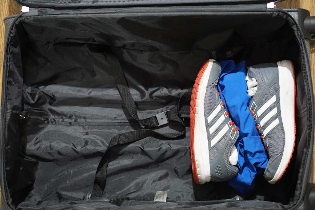 packing sneakers in a suitcase and layering