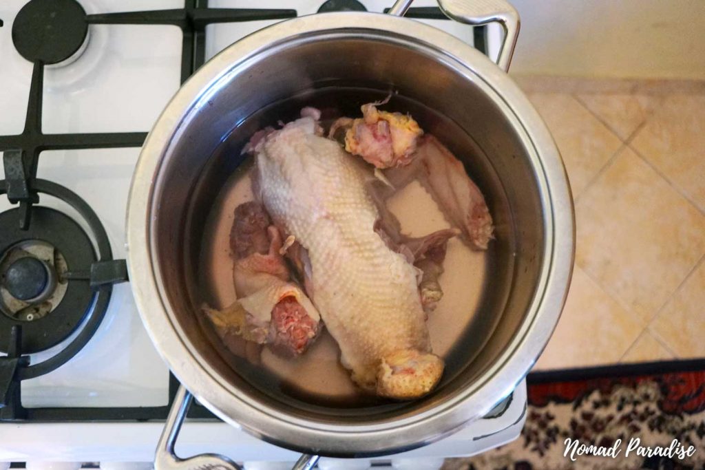 Making chicken noodle soup (adding the chicken carcass and bits to a pot of boiling water).