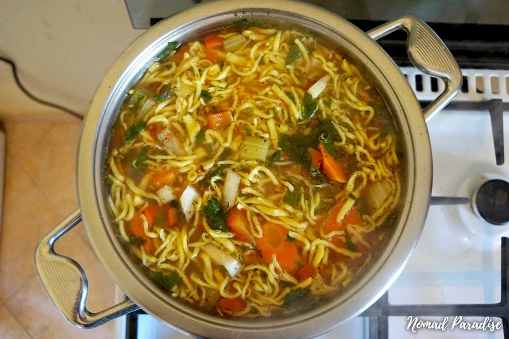 Chicken noodle soup, ready to be served, in a pot.
