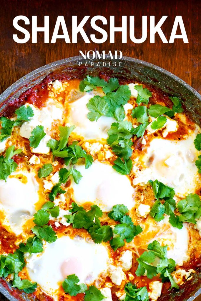 Shakshuka in a pan, topped with parsley and feta cheese.