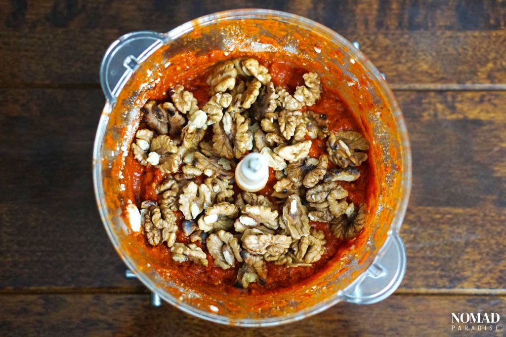 Muhammara recipe step by step (peeled roasted peppers, garlic, tomato paste with spices, pomegranate molasses, garlic, and walnuts in the food processor).