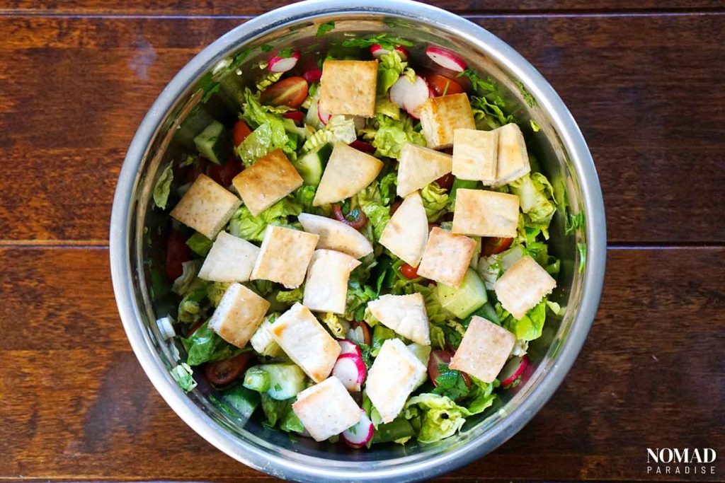 Fattoush Salad Step-by-Step (adding the pita chips to the salad bowl).
