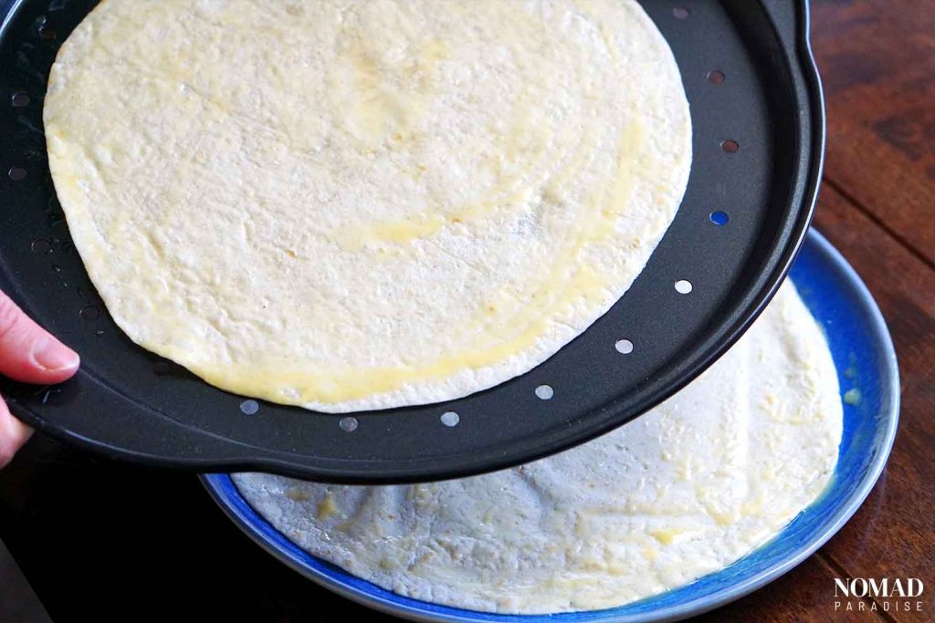 placing the tortillas on a pizza pan