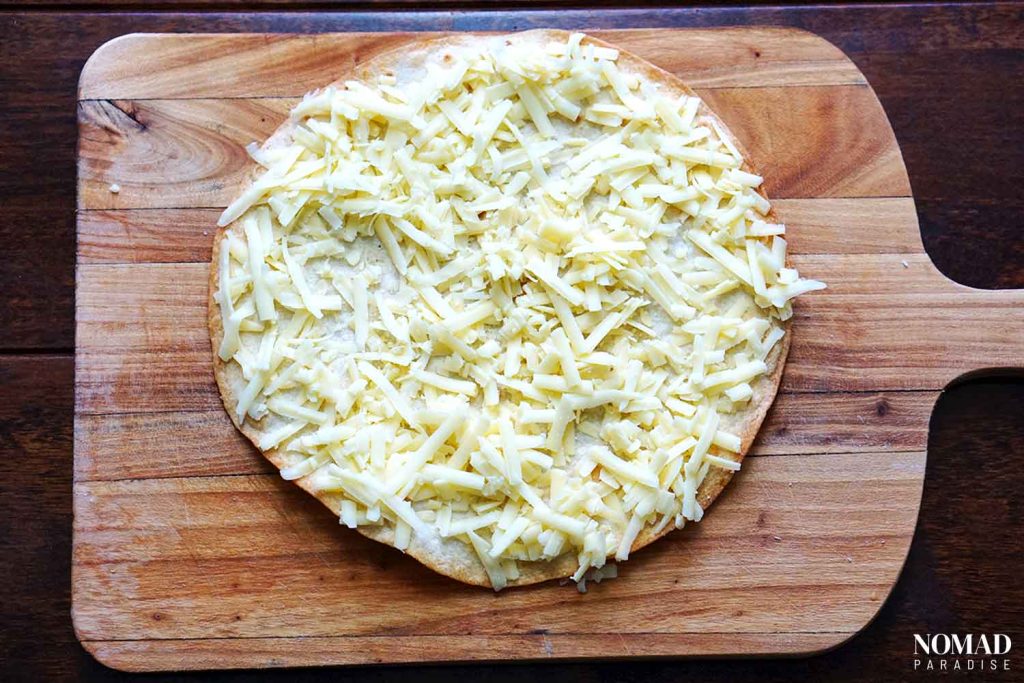 adding shredded cheese to the tortilla