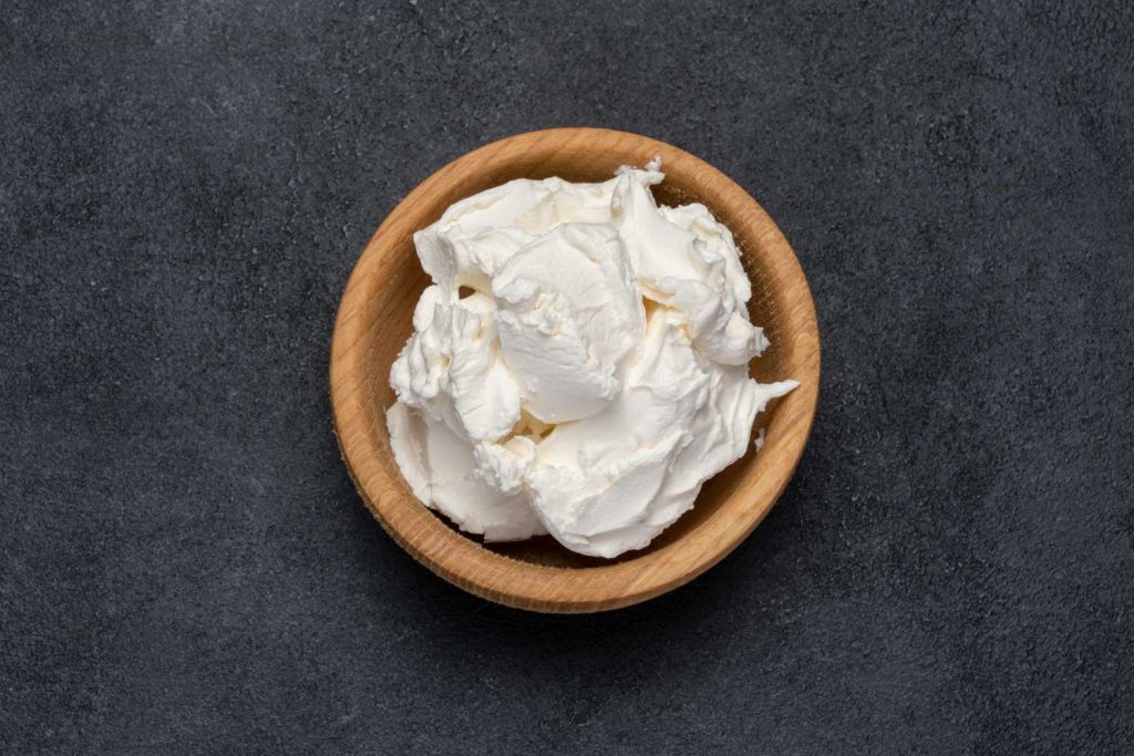 Mascarpone in a wooden bowl on the table