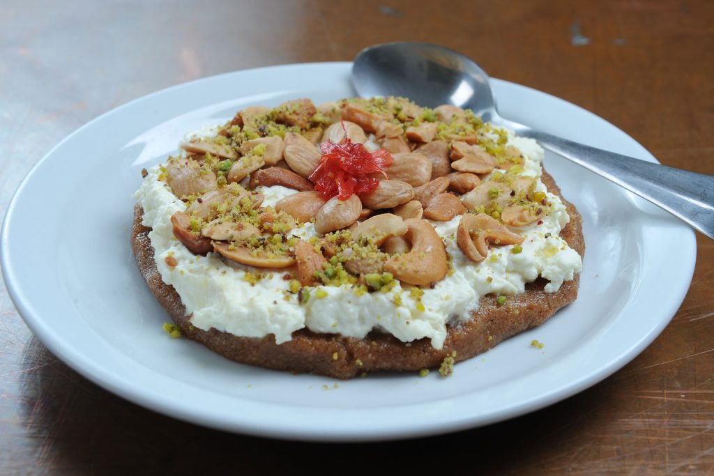 Mafroukeh on a small white plate with a small spoon.