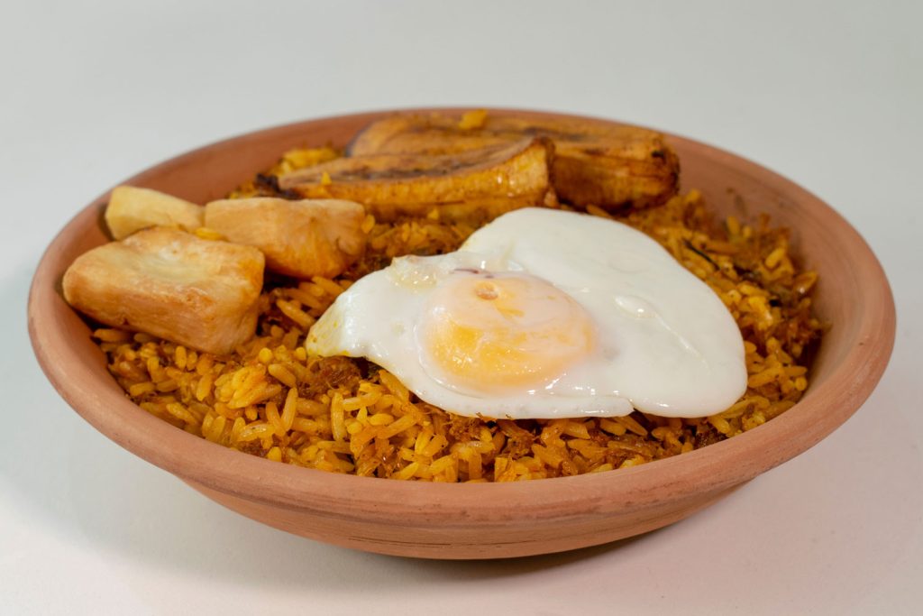 Majadito (Rice with Shredded Jerky, Cassava, and Vegetables) in a bowl, topped with a fried egg.