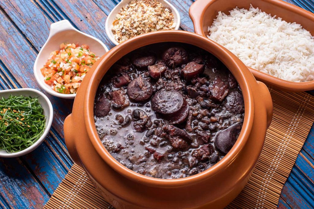 Feijoada (Black Bean and Pork Stew) with various sides.