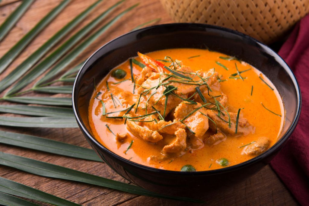Red creamy curry served in a nice dark bowl.
