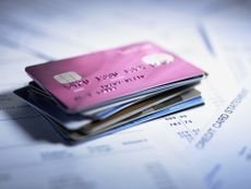 A stack of credit cards sitting on financial papers. 