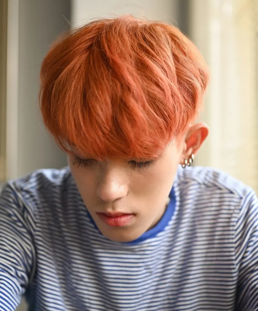 Asian boy with medium length copper hair